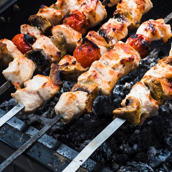 Chicken and vegetable skewers grilling over hot coals at Alice's Bar-B-Que.